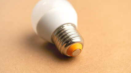 A light bulb is sitting on a table. The bulb is a standard incandescent bulb, but it is missing its...