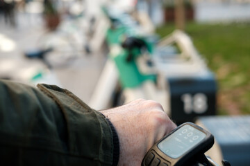 Man renting electric bike using mobile application in sharing station