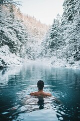 Fototapeta premium Male enjoys icy lake swim surrounded by snowy forest in winter wonderland