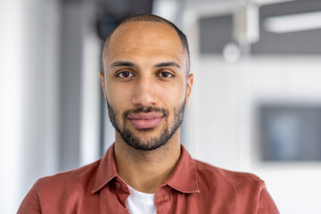 Close-up portrait of a man looking at the camera, serious and confident. Businessman at workplace...