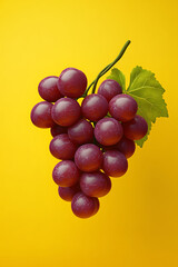 Fototapeta premium A cluster of purple grapes against a bright yellow background.