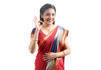 Traditional Indian Young woman  in saree stands and making OK sign 