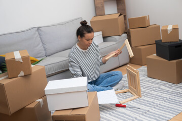 DIY Home Improvement: A close-up of a woman meticulously assembling a newly purchased wooden shelf...