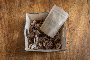 Paris, France - 02 15 2023: Madagascar Island Gastronomy Still Life. A basket and a bag filled with Dry Kaffir lime and powder placed on a wooden table.