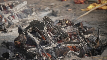 Traditional Indian cremation site with wood pyres burning intensely