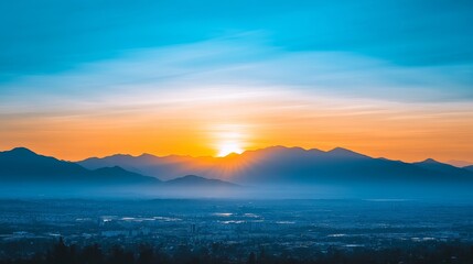 Obraz premium Golden Sunrise Over City and Mountain Range