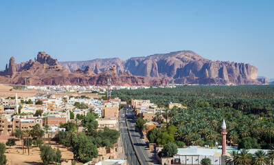 Top view of  Saudi Arabia Alula town surrounded by date trees and rock mountains in a sunny day.