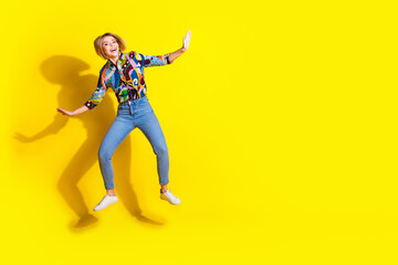 Full length photo of lovely young lady jump flying surfing dressed stylish colorful garment isolated on yellow color background