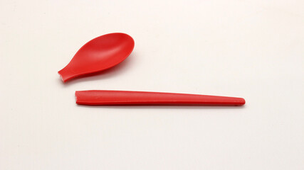 Broken red plastic spoon isolated