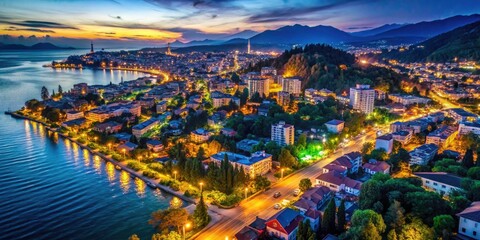 Fototapeta premium Aerial view: Sukhumi's resort town glows, a vibrant tapestry of city lights at night.
