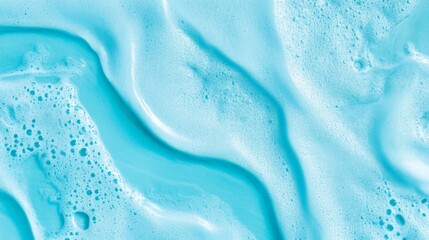 Cosmetic foam, shaving foam, or shampoo bubbles creating a wavy pattern on a light blue background, perfect for hygiene and beauty product concepts