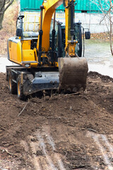 Obraz premium Excavator work in dust and dirt: heavy machinery works tirelessly on the construction site.