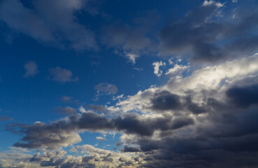 Gray-white clouds create a mysterious pattern on the twilight sky.