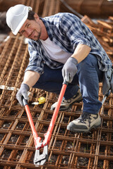 man using pliers on metal pattern tray