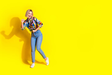 Full size photo of pretty young girl dancing good mood wear trendy colorful outfit isolated on yellow color background