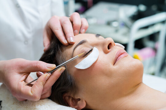 woman having eye lashes tinted in beauty salon