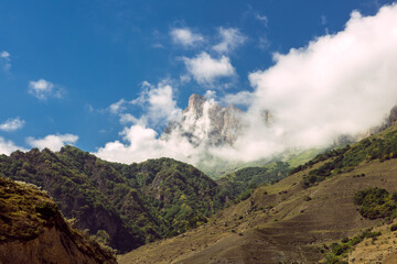 Caucasus, green mountains. View on the enchanting hills and blue sky with white cottony clouds