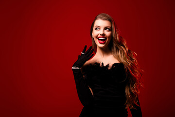 Photo of amazed lady with long curly hair wearing gown expensive gems look empty space red color...