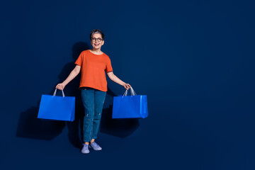 Full length photo of lovely pensioner lady hold shopping bags dressed stylish orange garment...