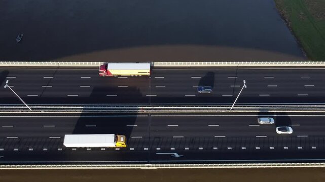 Zwolle, the Netherlands - January 8th 2025: Top down aerial footage of traffic crossing a river over a highway bridge.