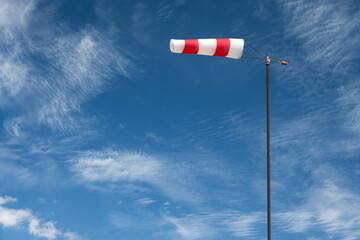 Fabric Wind Indicator on Mast Against Sky and Clouds