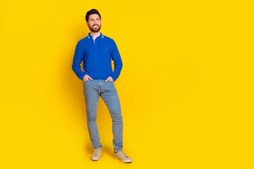 Full body photo of attractive young man look empty space posing model dressed stylish blue clothes isolated on yellow color background