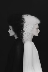Black and White Photo of Two Women, One in a Black Dress and the Other in a White Dress, Against a Black Background.