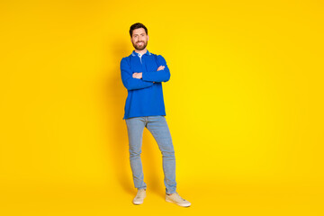 Full body photo of attractive young man crossed hands confident dressed stylish blue clothes isolated on yellow color background