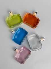 set off multi-colored bottles with liquid for ultrasonic aromas lie on a gray background, flat lay.
