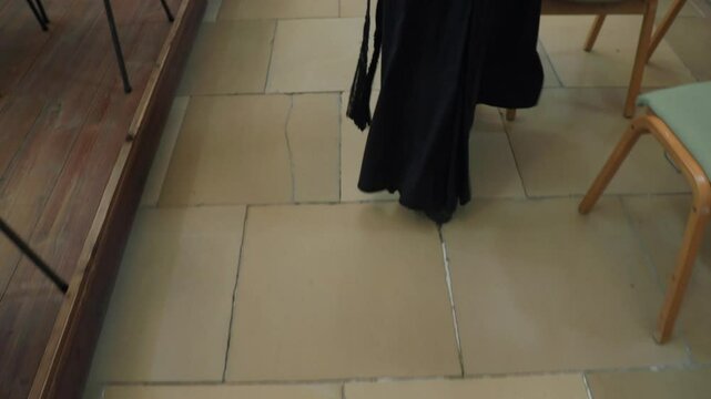 priest walking over marble floor in church