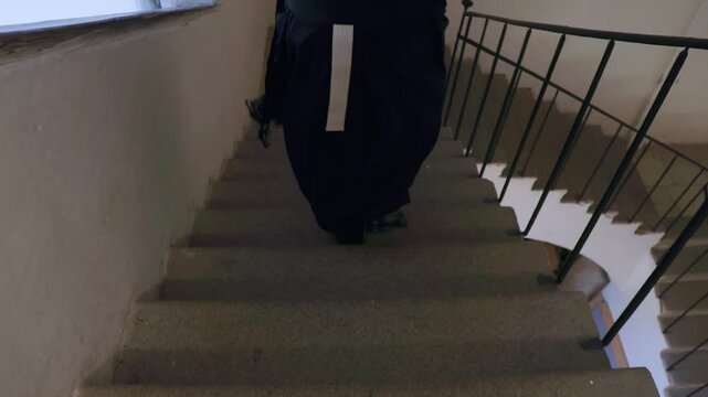 priest descending staircase in church