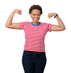 Fototapeta premium Beautiful young african american woman wearing glasses over isolated background showing arms muscles smiling proud. Fitness concept.