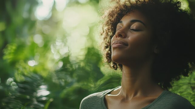 A woman practicing mindfulness meditation outdoors in a serene forest, promoting mental health and relaxation