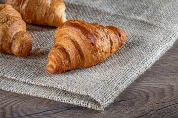 Croissants on a burlap napkin on a kitchen table