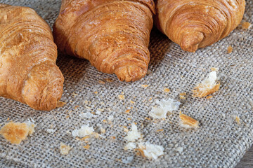 Croissants on a burlap napkin on a kitchen table