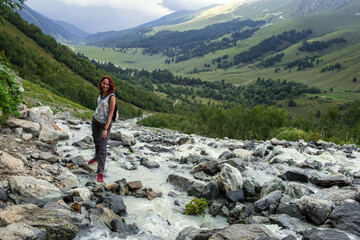 Girl posing - beautiful waterfalls mountainous background with streaming river