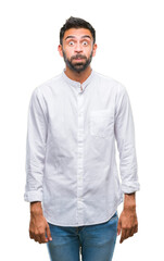 Adult hispanic man over isolated background puffing cheeks with funny face. Mouth inflated with air, crazy expression.