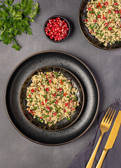 Food photography of salad tabouleh with pomegranate, bulgur; parsley, mint, tomato, spring onion, vegan dish, Arabian food