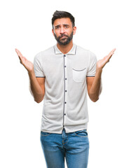 Adult hispanic man over isolated background clueless and confused expression with arms and hands...
