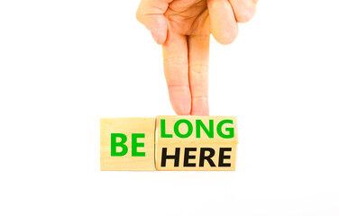 Belonging and belong symbol. Concept words Be here Belong on beautiful wooden block. Beautiful white background Businessman hand. Business motivational belonging and belong concept. Copy space.