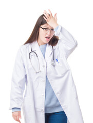 Young Chinese doctor woman over isolated background surprised with hand on head for mistake, remember error. Forgot, bad memory concept.