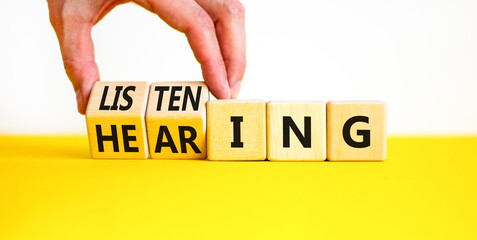 Listening or hearing symbol. Businessman turns wooden cubes and changes a concept word Listening to...
