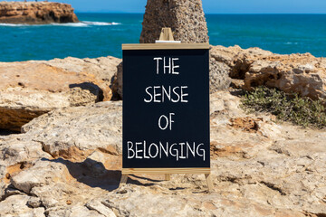 The sense of belonging symbol. Concept words The sense of belonging on beautiful black blackboard. Beautiful stone and blue sea sky background. Business and the sense of belonging concept. Copy space.