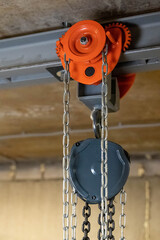 Chain hoist lifting equipment hanging from ceiling in warehouse