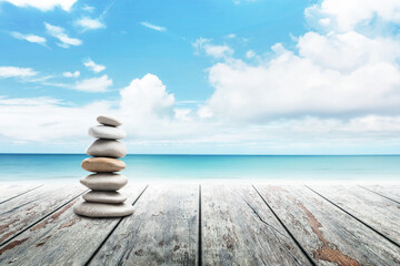 Stack of pebble stones at the beach on a wooden surface. Concept Zen, Spa, Summer, Beach, Sea, Relax.