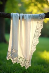 Soft white lace fabric draped over a tree branch in morning light, peaceful ambiance, white fabric