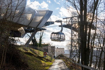 Modern cable car gondola station in a scenic natural setting, surrounded by trees, with futuristic architectural details. Ideal for showcasing innovation in urban transportation and eco-friendly trave