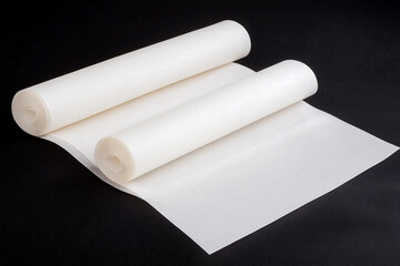 Fototapeta premium White parchment paper rolls on a dark surface