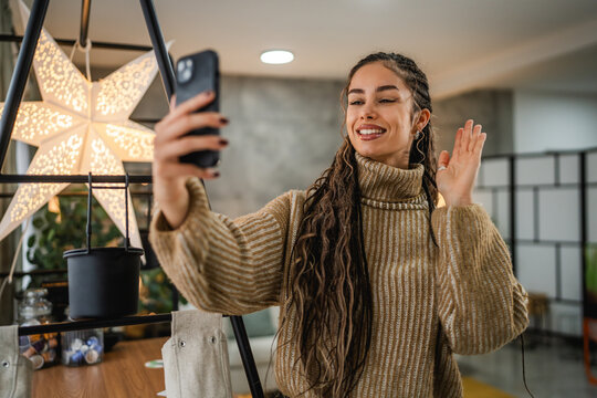 young woman talk and wave on video call via mobile phone