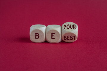 Wooden cubes with words Be your best. Beautiful pink background. Business motivational be your best...